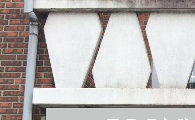Lysskilt med sølvgrå bund, sorte bogstaver med hvid kontur. Rød logo og striber i translucent folie.